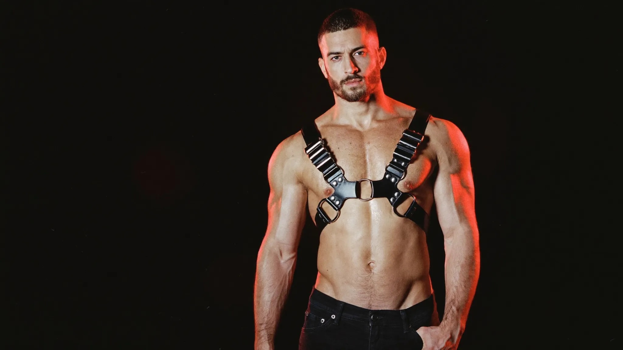 Model in the SRL Bulldog Harness lit by a single red light against black